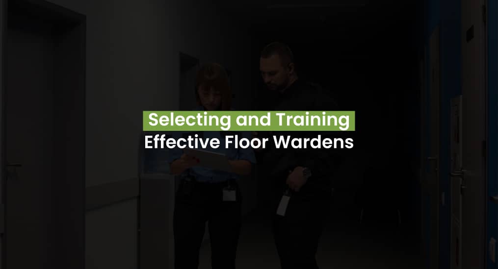 A floor warden and a colleague reviewing emergency procedures in a hallway.